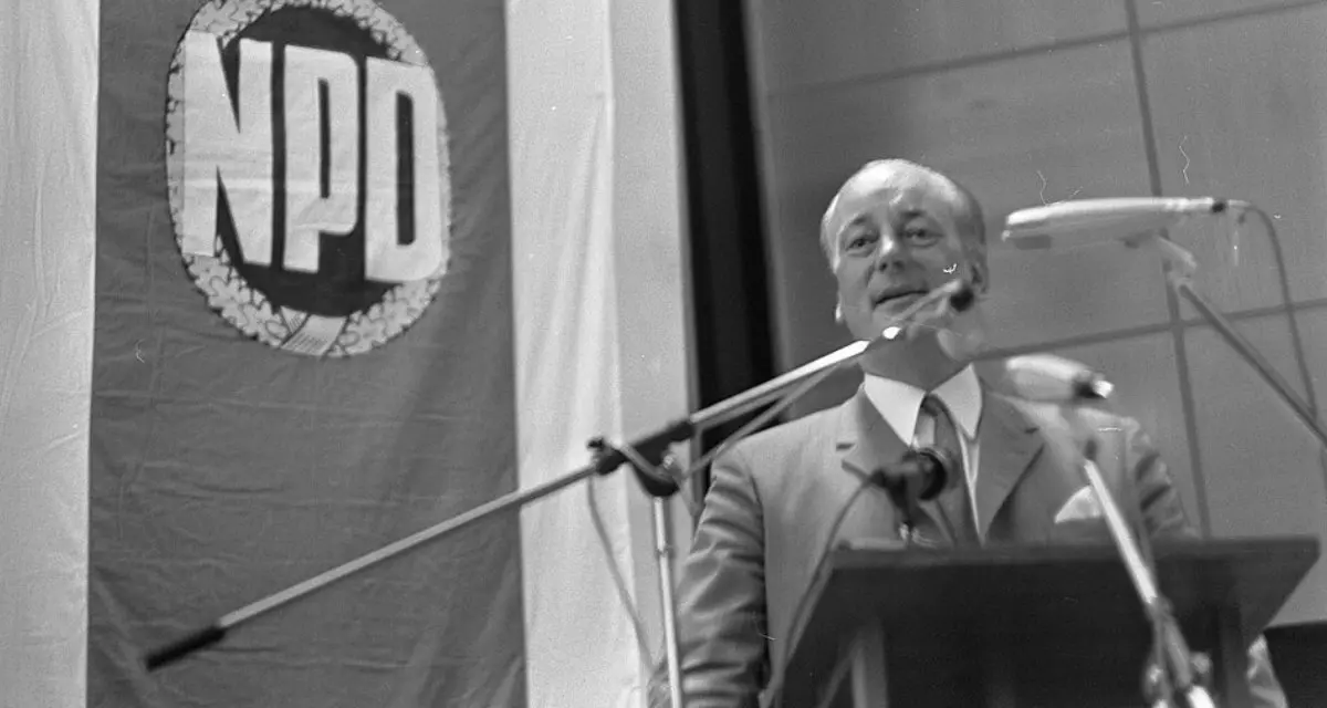 NPD_verkiezingsbijeenkomst_in_Nordhorn,_Duitsland_Adolf_Von_Thadden_spreekt,_Bestanddeelnr_922-7336. Bild: Wikimedia | Eric Koch for Anefo | CC0 1.0 | https://creativecommons.org/publicdomain/zero/1.0/deed.en NPD_verkiezingsbijeenkomst_in_Nordhorn,_Duitsland_Adolf_Von_Thadden_spreekt,_Bestanddeelnr_922-7336. Bild: Wikimedia | Eric Koch for Anefo | CC0 1.0 | https://creativecommons.org/publicdomain/zero/1.0/deed.en